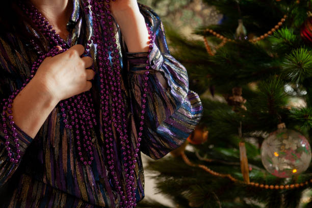 Hands hang garland on Christmas tree close up stock photo