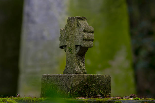 Cross Headstone in a dilapidated graveyard stock photo