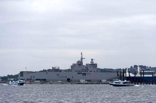 Moored helicopter carrier warship Dixmude L-9015 of French Navy at Toulon Naval Base on a cloudy spring day. Photo taken June 9th, 2023, Toulon, France.