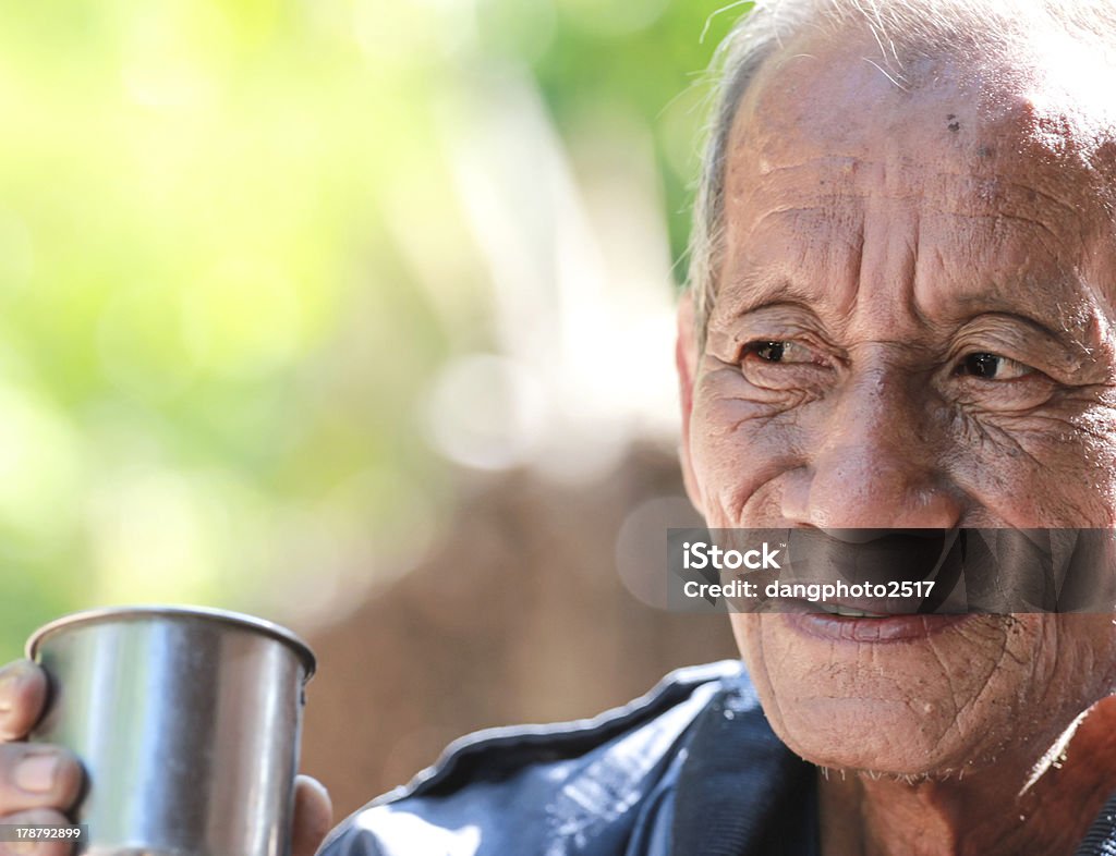 aged cheerful old man holding  cup of coffee aged cheerful old man holding cup of coffee Active Seniors Stock Photo