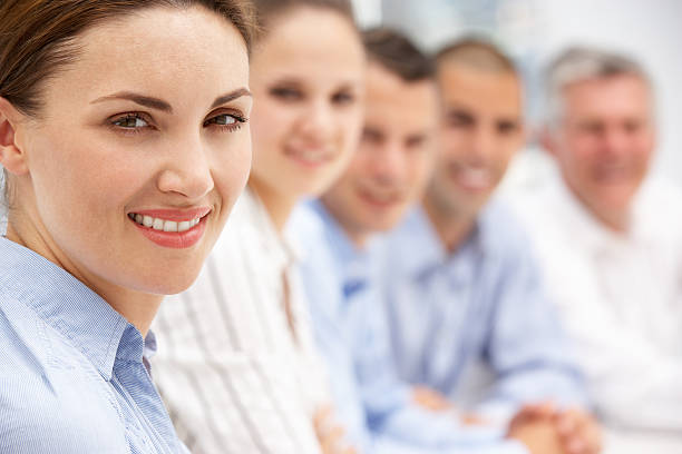 Portrait of a businesswoman standing in front of her colleagues during a meeting