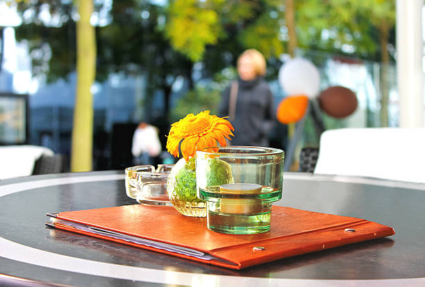 Flower,  menu and  candle on  table in  cafe.