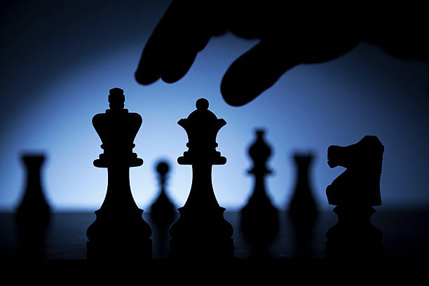 Silhouette of chess set and hand ready to play stock photo