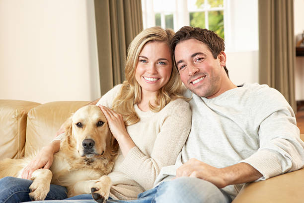 istock Young happy couple with dog sitting on sofa 178796402