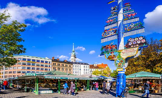 Bruges, Belgium - June 27, 2023: The historic town square Markt in the heart of Bruges city center. The city's most famous monuments is the 12th-century bell tower with restaurants, cafes and shops against the medieval buildings.