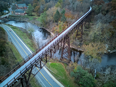 drone view of rosendale trestle passing over rondout creek at dusk (sunset, low light) old railroad bridge converted to bike, pedestrian path (cycling, biking, walking, jogging, walkill valley rail trail)