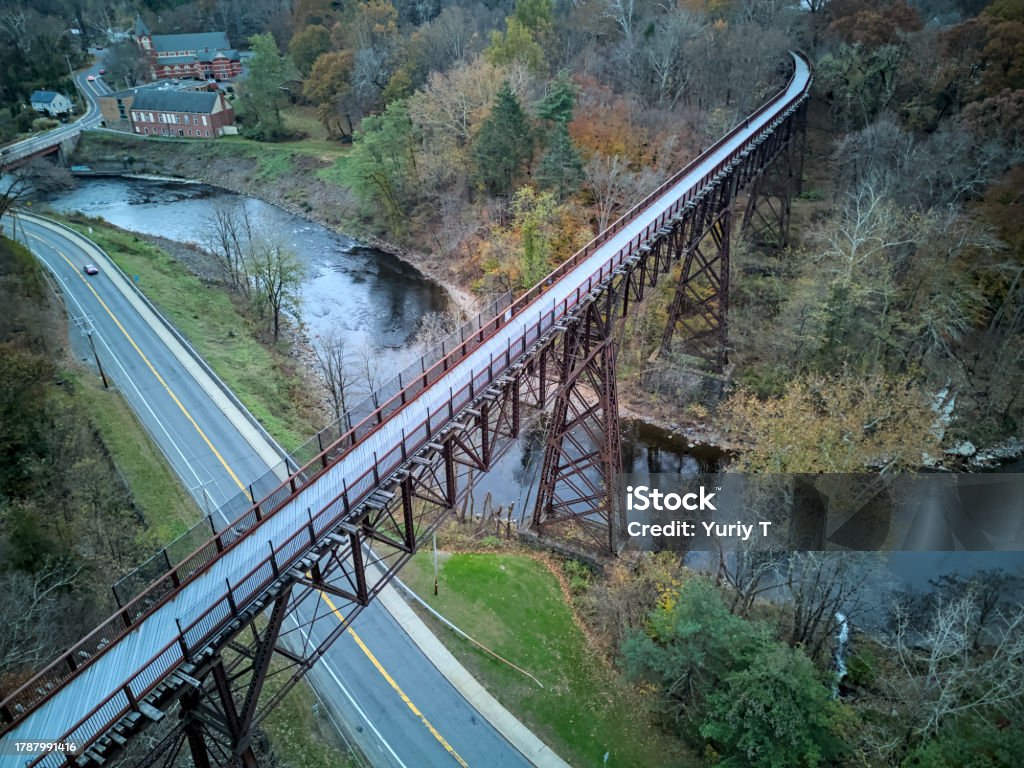 drone view of rosendale trestle passing over rondout creek at dusk (sunset, low light) old railroad bridge converted to bike, pedestrian path (cycling, biking, walking, jogging, walkill valley rail trail) Above Stock Photo