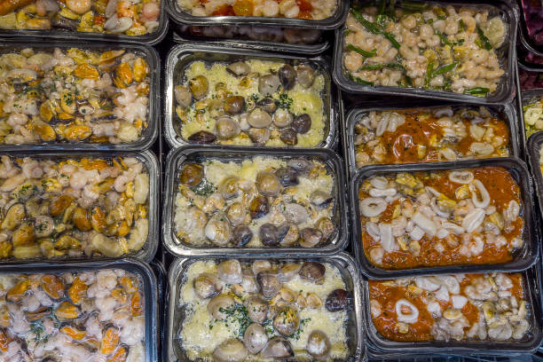 Soups and sauces with shellfish and fish precooked in vacuum trays sealed for sous vide cooking for sale in supermarket refrigerated counters