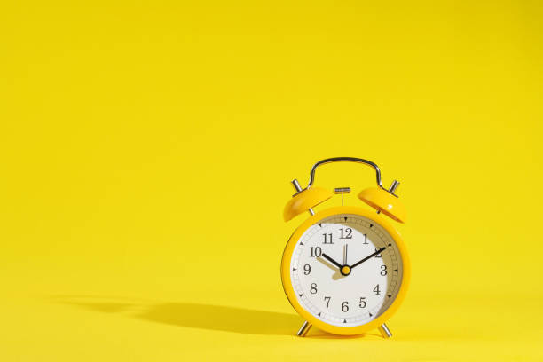 istock stationery, apple and retro alarm clock on a bright yellow background 1787996143