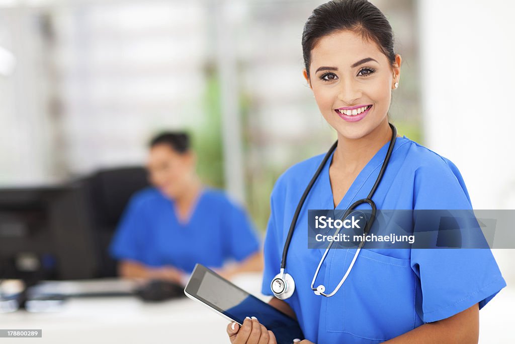 Female nurse in blue uniform with tablet attractive young female nurse holding tablet computer at workplace Nurse Stock Photo