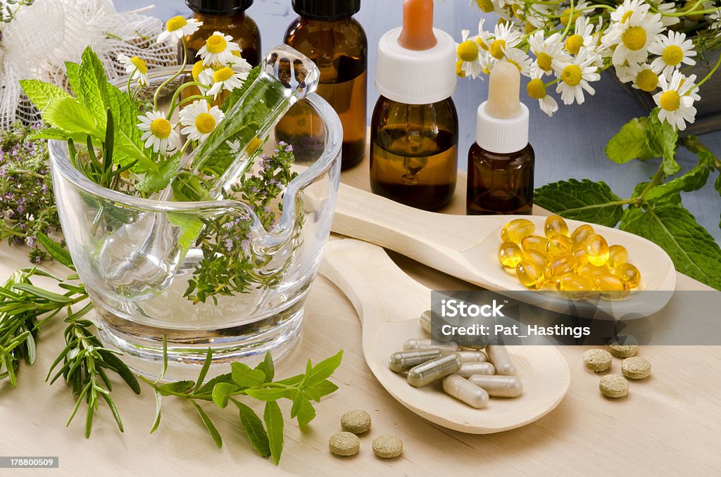 Alternative Medicine. Alternative Medicine. Rosemary, mint, chamomile, thyme in a glass mortar. Essential oils and herbal supplements. Alternative Medicine Stock Photo