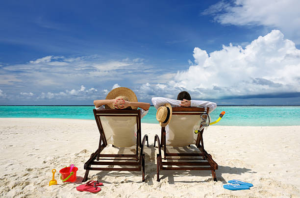 Couple on a beach Couple on a tropical beach at Maldives flip flop sandal beach isolated stock pictures, royalty-free photos & images