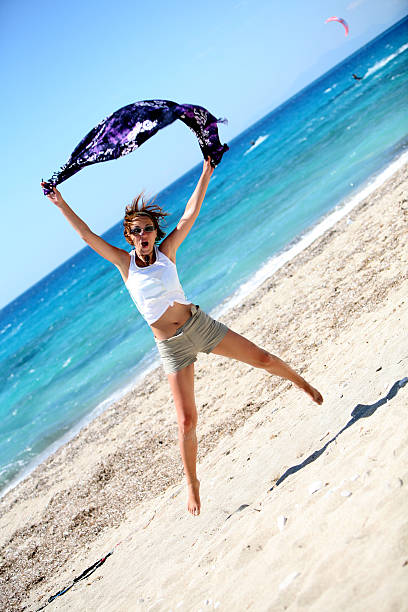 Giovane donna saltando sulla spiaggia - foto stock