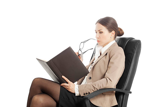 istock concentrated woman in chair reading from a notebook 178802261