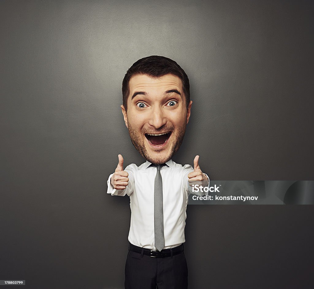 happy businessman with big head laughing happy businessman with big head showing two thumbs up and laughing. funny picture over dark background Large Stock Photo