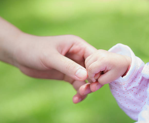 istock little baby holding mother's hand 178804201