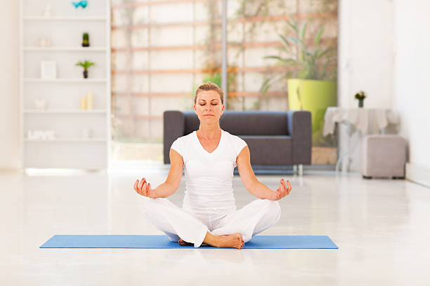 istock middle aged woman doing yoga meditation 178806351