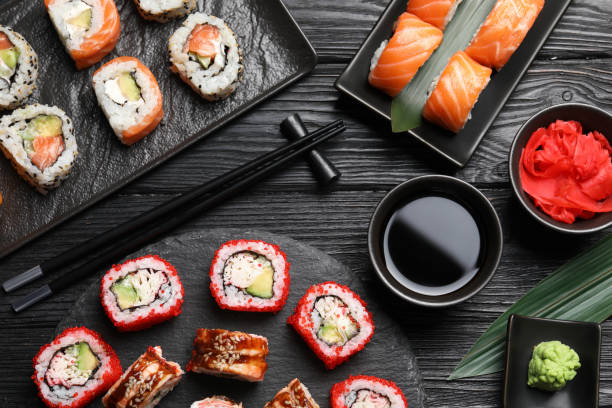 istock Flat lay composition with different sushi rolls on black wooden table 1788064558