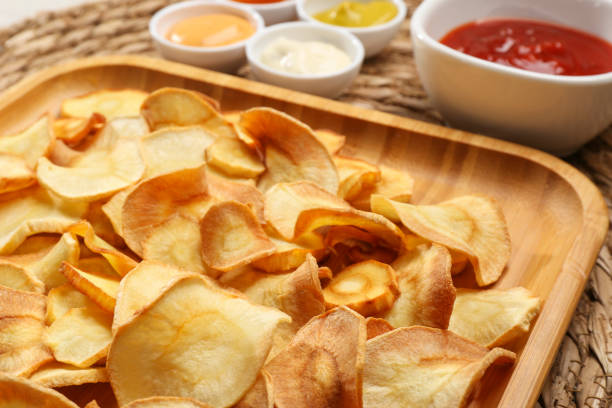 istock Tasty homemade parsnip chips with different sauces on wicker surface, closeup 1788073110