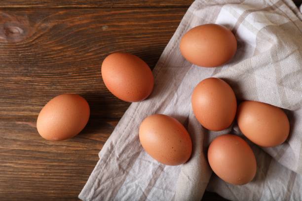 istock Raw brown chicken eggs on wooden table, flat lay 1788079924