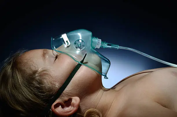 Photo of Little, sick girl in mask oxygen.