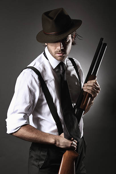 istock Handsome gangster posing with shotgun and hat 178809839