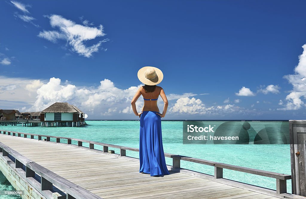 Woman on a beach jetty at Maldives Woman on a tropical beach jetty at Maldives Adult Stock Photo