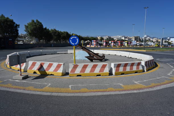港近くのギリシャのイラクリオン市にあるコンクリートの障壁と青い交通標識のあるラウンドアバウト。 - traffic sea passage overpass car ストックフォトと画像