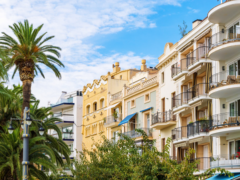 Beautiful architecture, residential buildings and palm trees in a tourist city Sitges, Catalonia, Spain, city life.