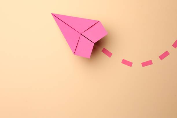 istock Handmade pink paper plane with dotted lines on beige background, top view. Space for text 1788118721