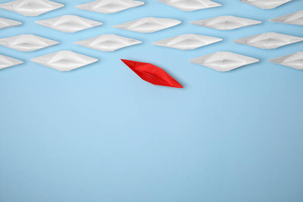 istock Red paper boat floating away from others on light blue background, flat lay with space for text. Uniqueness concept 1788119814