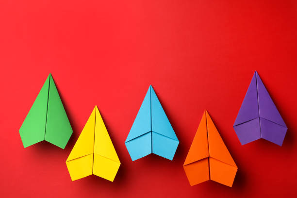 istock Handmade colorful paper planes on red background, flat lay. Space for text 1788120338
