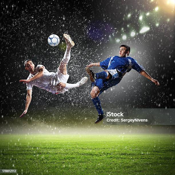 Two Football Players Striking The Ball Stock Photo - Download Image Now - Above, Activity, Adult