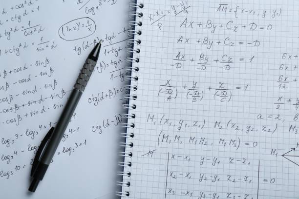 Paper with different mathematical formulas and pen, top view