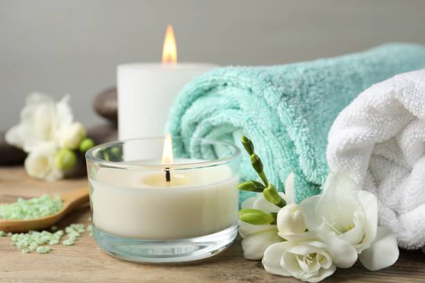 istock Beautiful composition with burning candles and different spa products on wooden table, closeup 1788132597