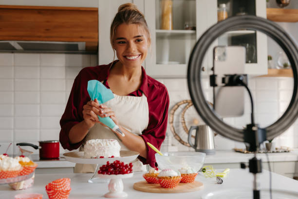 istock Confident female baker applying whipped cream on cake while streaming online from the kitchen 1788134192