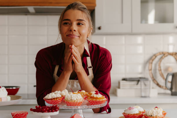 istock Thoughtful young female baker looking thoughtful while leaning on the table with variety of sweet food 1788152204