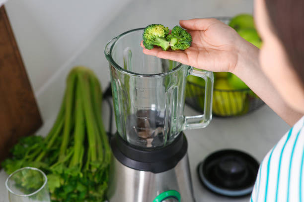 istock Woman adding broccoli into blender for smoothie in kitchen, closeup 1788157881