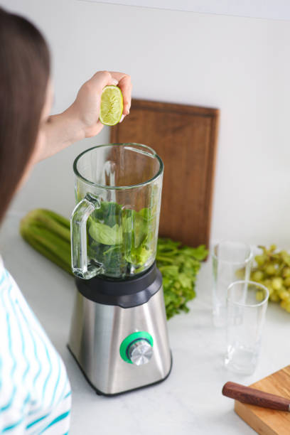 istock Woman adding lime juice into blender with ingredients for smoothie in kitchen, closeup 1788157887