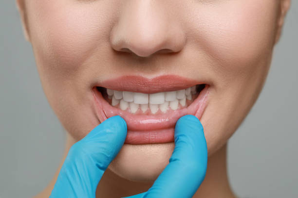 istock Doctor examining woman's gums on grey background, closeup 1788158963