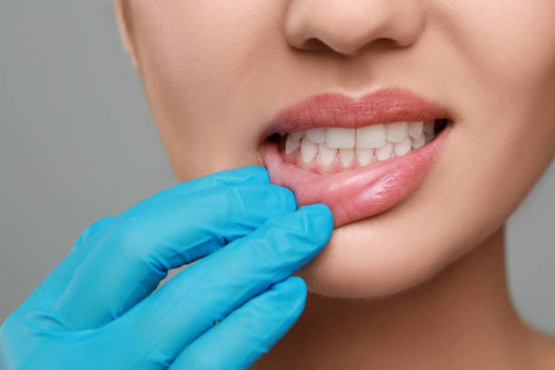 istock Doctor examining woman's gums on grey background, closeup 1788160625