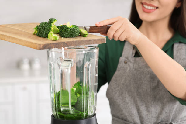 istock Woman adding broccoli into blender with ingredients for smoothie in kitchen, closeup 1788161704