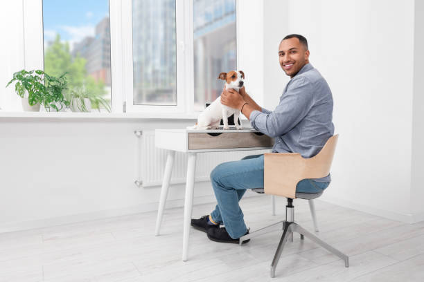 istock Young man with Jack Russell Terrier at desk in home office 1788176929