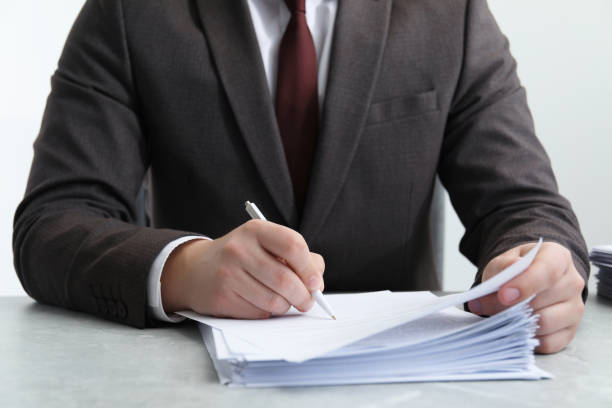 istock Man signing document at table in office, closeup 1788178506