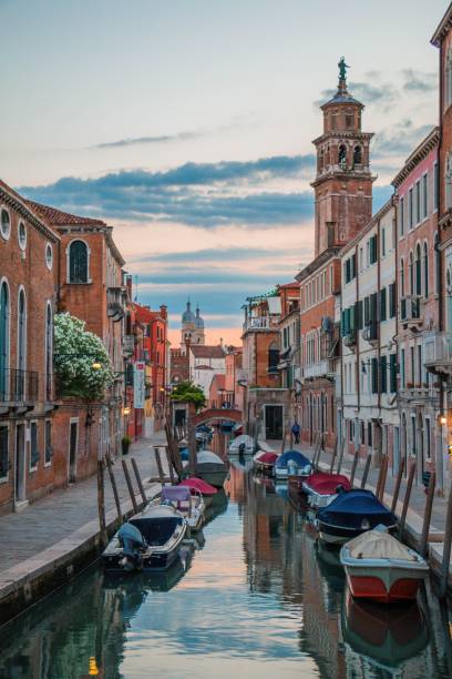istock a waterway with boats floating next to a tall building and a clock tower 1788182168