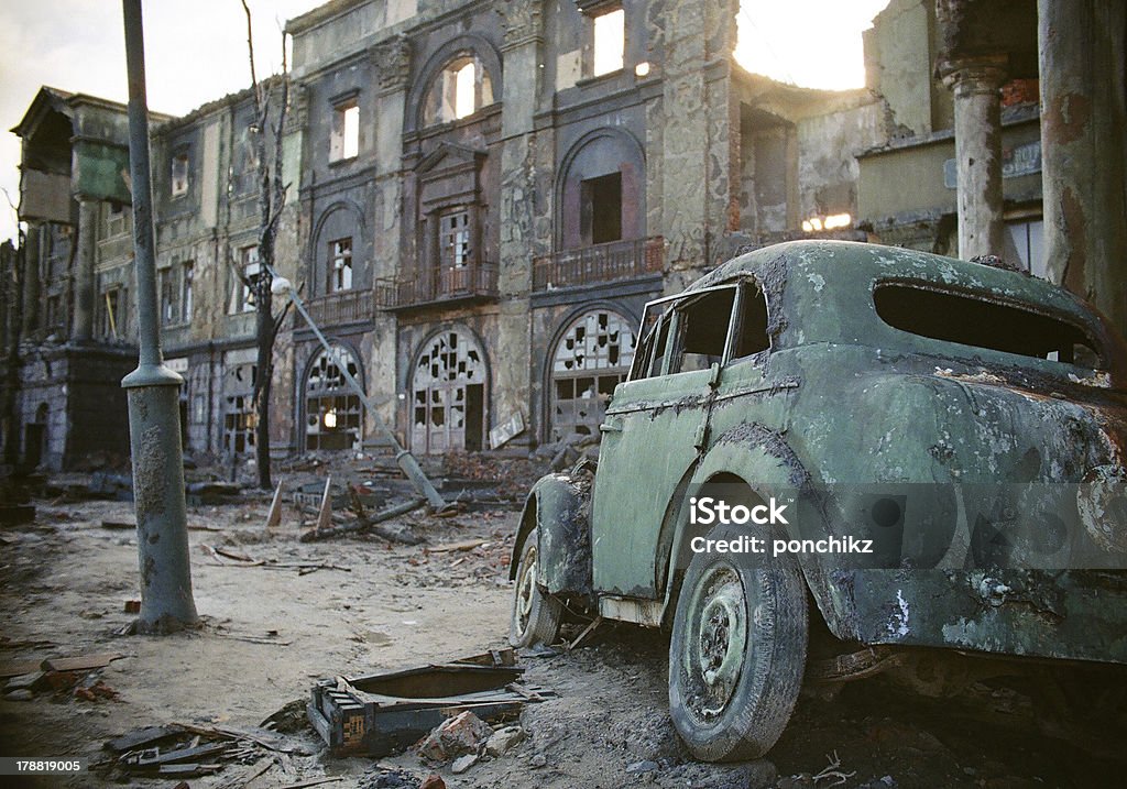 sad consequences of the war broken car against the background of destroyed buildings City Stock Photo