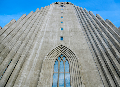 Reykjavík, Capital Region, Iceland: looking up the Hallgrímskirkja façade (Hallgrím Church) - an Evangelical Lutheran parish church of the  Evangelical Lutheran Church of Iceland (State Church of Iceland), the largest church building in Iceland and the second tallest building in the country after the Smáratorg Tower - built in 1945-1986 and named after17th-century clergyman Hallgrímur Pétursson, author of Hymns of the Passion. The building was designed by the state architect Guðjón Samúelsson. The external appearance is dominated by the Expressionist style, similar to the Grundtvig's Church in Copenhagen (1940). The concrete pillars are inspired by basalt columns / trap rocks, a common motif in the Icelandic landscape.