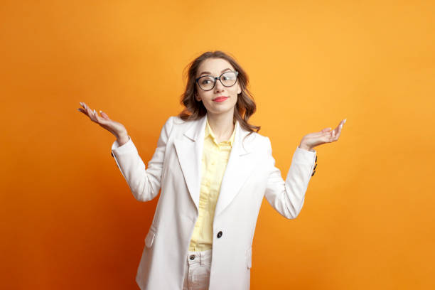 unsure business woman in glasses and suit shrugs her shoulders on colored background, confused manager girl - bolero jacket imagens e fotografias de stock