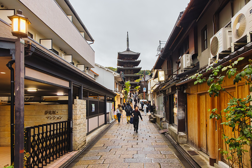Kyoto, Japan - April 15, 2023: Yasaka Pagoda seen from an alley, with unidentified people. Yasaka Pagoda is a Buddhist pagoda in Kyoto and a tourist attraction