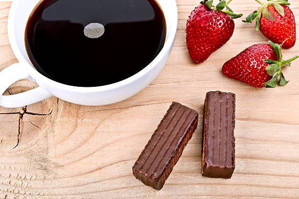 strawberry with a cup of coffee and chocolate on wood stock photo